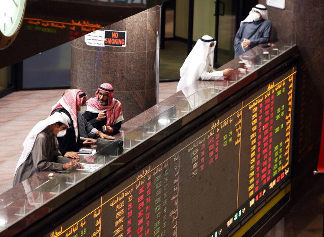 Kuwaiti traders wearing protective masks follow the market at the Boursa Kuwait stock exchange in Kuwait City on March 1, 2020. - Boursa Kuwait decided to close the main trading hall due to the COVID-19 coronavirus disease developments. Stock markets in the oil-rich Gulf states plunged on March 1 over fears of the impact of the coronavirus, which also battered global bourses last week. All of the seven exchanges in the Gulf Cooperation Council (GCC), which were closed the previous two days for the Muslim weekend, were hit as oil prices dropped below $50 a barrel. The region‘s slide was led by Kuwait Boursa, where the All-Share Index fell 10 percent, triggering its closure. Kuwait’s bourse was closed for most of last week for national holidays. (Photo by YASSER AL-ZAYYAT / AFP)    쿠웨이트 시티의 쿠웨이트 증권거래소에서 1일(현지시간) 마사크를 쓴 트레이더들이 모여 서 있다. 쿠웨이트 증권거래소는 신종 코로나바이러스 감염증(코로나19)으로 메인 거래 홀을 폐쇄하기로 결정했다. /쿠웨이트시티=AFP연합뉴스     <저작권자(c) 연합뉴스, 무단 전재-재배포 금지>