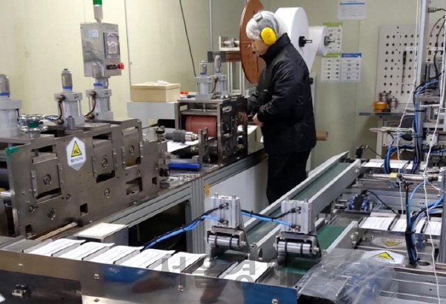 마스크 제조사 에이치메디스의 근로자가 공장에서 마스크 제조장비를 점검하고 있다. /사진제공=에이치메디스