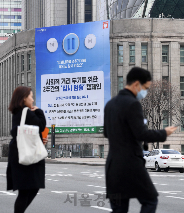 정부가 신종 코로나바이러스 감염증(코로나19) 예방을 위해 사회적 거리 두기를 강조한 가운데 4일 오전 서울 중구 서울도서관 외벽에 사회적 거리 두기를 위한 2주간의 '잠시 멈춤' 캠페인을 알리는 현수막이 걸려 있다./권욱기자 2020.3.4