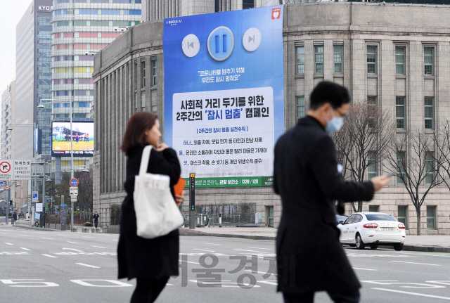 정부가 신종 코로나바이러스 감염증(코로나19) 예방을 위해 사회적 거리 두기를 강조한 가운데 4일 오전 서울 중구 서울도서관 외벽에 사회적 거리 두기를 위한 2주간의 '잠시 멈춤' 캠페인을 알리는 현수막이 걸려 있다./권욱기자 2020.3.4