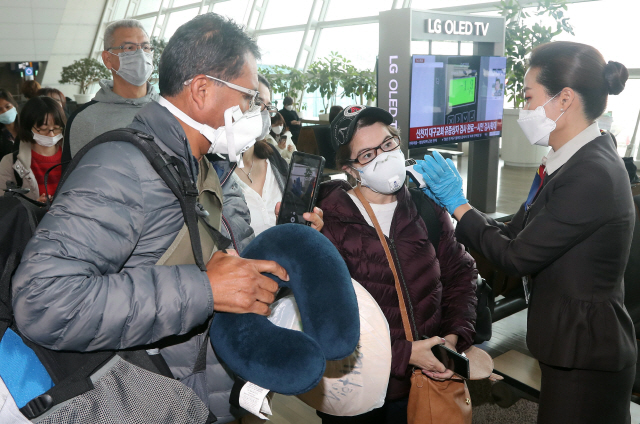 국토교통부는 5일 인천국제공항을 이용하는 항공기 탑승객을 대상으로 공항 도착부터 항공기 탑승까지 3단계에 걸쳐 발열검사를 시행한다고 밝혔다. 사진은 지난 3일 인천국제공항 제1여객터미널 탑승 게이트 앞에서 미국행 항공기 탑승객들이 발열 검사를 받고 있는 모습. /연합뉴스