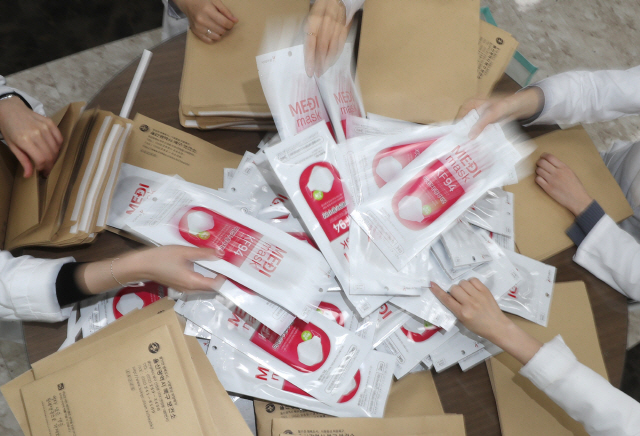 5일 오후 울산 북구보건소에서 보건소 관계자들이 관내 저소득 의료취약계층에 보낼 마스크를 봉투에 넣고 있다./연합뉴스