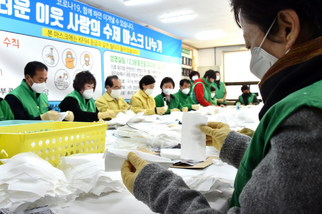 오거돈 부산시장과 부산시새마을부녀회 회원들이 필터 교체형 수제 마스크를 만들고 있다./사진제공=부산시