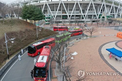 대구에서 신종 코로나바이러스 감염증 확진자가 늘어나며 병상이 부족해지자 지난 3일 대구스타디움에 모인 경증 확진자들이 버스를 타고 생활치료센터로 이동하고 있다./연합뉴스