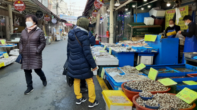 6일 서울 강동구 성내전통시장의 한 수산물 가게에서 마스크를 쓴 상인들이 손님들에게 판매할 해산물을 손질하고 있다./김혜린기자