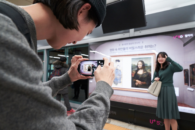 서울 지하철 6호선 공덕역에 마련된 5G기반 문화예술 공간 ’U+5G 갤러리’에 방문한 고객이 ‘U+AR(증강현실)’ 앱으로 작품을 체험해보고 있다./사진제공=LG유플러스