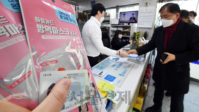 지난 6일 오전 서울 종로구의 한 약국에서 약사들이 신분증과 통합시스템으로 마스크 구매 이력을 확인한 뒤 마스크를 판매하고 있다./오승현기자