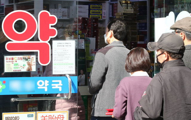 8일 서울 시내 한 약국에서 시민들이 공적 마스크 구입을 위해 줄을 서고 있다./연합뉴스
