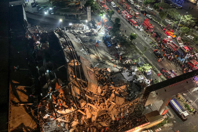 코로나19 확산 방지를 위해 강제 격리시설로 쓰이던 중 지난 7일 저녁(현지시간) 붕괴된 중국 푸젠셍 취안저우의 호텔 건물이 무너진 잔해 속에 휘어진 철골을 드러내고 있다.  /취안저우=AFP연합뉴스