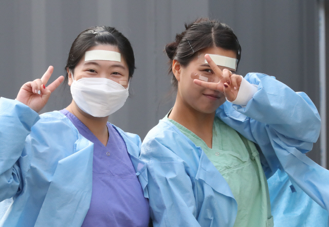 대구시 신종 코로나바이러스 감염증(코로나19) 지역거점병원인 계명대학교 대구동산병원에서 확진자 병동에서 일하는 의료진이 밝은 표정으로 카메라를 향해 ‘V’자를 그리고 있다./대구=연합뉴스