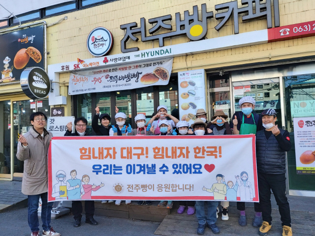 사회적기업 ‘전주비빔빵’ 임직원들이 9일 대구·경북 지역 의료진을 위해 2,000만원 상당의 제과류를 전달한 뒤 전북 전주 전주빵카페 매장 앞에서 기념촬영을 하고 있다. /사진제공=SK이노베이션