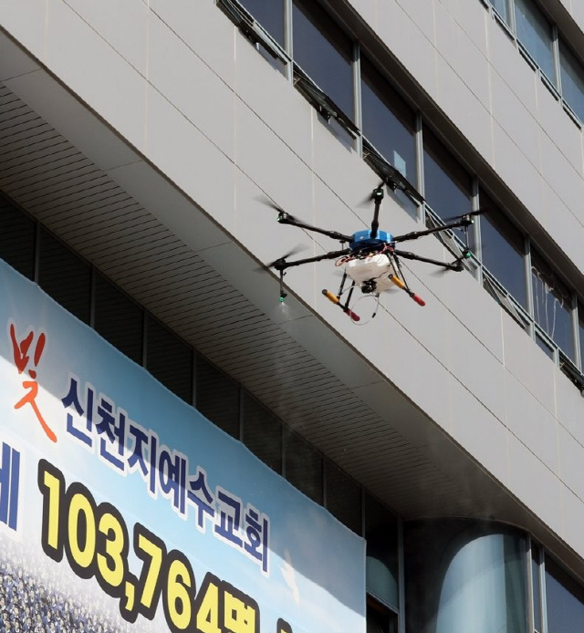 6일 오후 대구시 남구 대명동 신천지 대구교회 앞에서 남구청 관계자들이 드론을 이용해 방역을 하고 있다. / 사진=연합뉴스