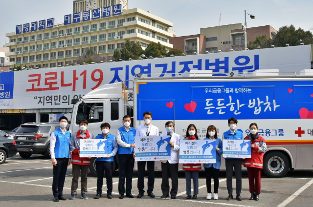 우리금융그룹은 지난 9일부터 대구 지역거점병원 의료진을 위해 건강식 수제도시락 ‘든든한 도시락’을 코로나19 사태가 진정될 때까지 매일 점심 지원하기로 했다. 우리금융그룹 관계자와 서영성(왼쪽 여섯번째) 대구동산병원장, 박선영(왼쪽 일곱번째) 대한적십자사 대구지사 사무처장 등이 의료진에 응원의 메시지를 보내고 있다. /사진제공=우리금융