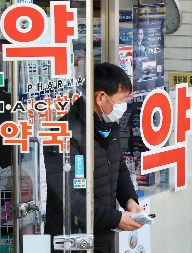 11일 서울 시내 한 약국에서 마스크를 구매한 시민이 약국을 나서고 있다. /연합뉴스