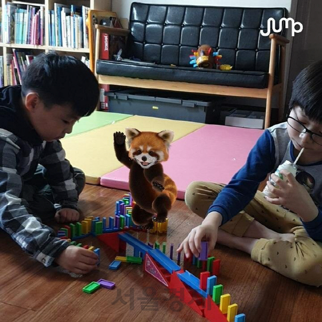 어린이들이 ‘점프AR(증강현실)’ 앱에서 AR로 구현된 레서판다와 함께 도미노 놀이를 하고 있다./사진제공=SK텔레콤