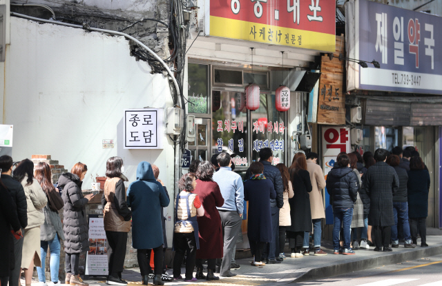 11일 서울 시내의 한 약국에서 시민들이 공적 마스크를 구매하기 위해 줄을 서서 기다리고 있다. /연합뉴스