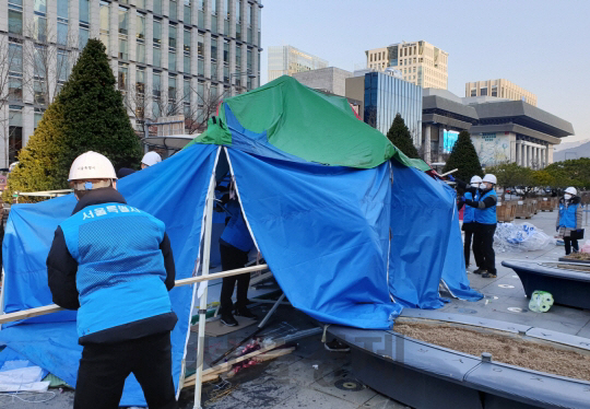 12일 오전 서울 공화문광장에서 서울시 관계자들이 시민단체 전두환심판국민행동이 설치한 불법 천막을 강제로 철거하고 있다. /연합뉴스