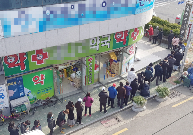 13일 부산 연제구의 한 약국 앞에서 공적 마스크를 사려는 시민이 자신의 차례를 기다리고 있다./연합뉴스