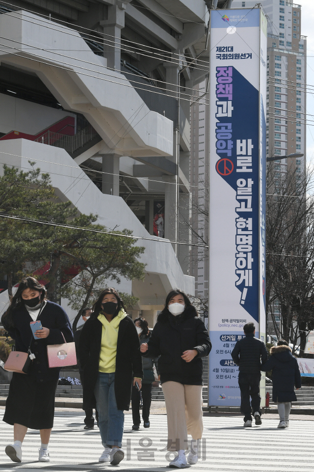 '제21대 국회의원 선거'를 1달 앞둔 15일 오후 시민들이 경기도 수원시 장안구청사거리에 유권자의 선거참여와 관심을 유도하기 위해 경기도선거관리위원회가 설치한 홍보 선전탑 앞을 지나고 있다./수원=오승현기자 2020.03.15