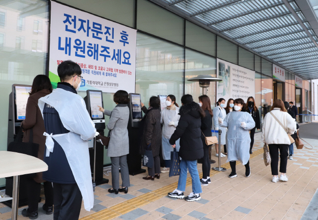 은평성모병원 방문객들이 1층 정문 밖에 설치된 키오스크를 통해 코로나19 의심환자 등을 걸러내기 위한 전자문진에 응하고 있다. /사진제공=은평성모병원