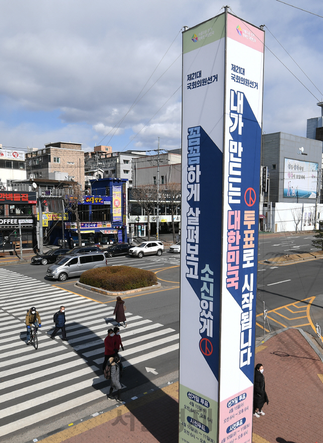 '제21대 국회의원 선거'를 1달 앞둔 15 오후 경기도 수원시 장안구청사거리에 설치된 선거 홍보 선전탑 앞에서 경기도선거관리위원회 관계자들이 유권자들에게 선거참여와 관심을 호소하고 있다./수원=오승현기자 2020.03.15