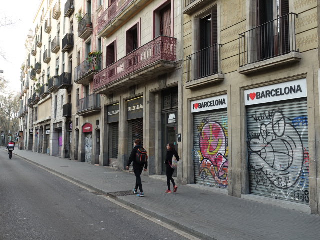 14일(현지시간) 스페인의 대표적 관광지인 바르셀로나에서 사람들이 문 닫힌 상점 앞을 걸어가고 있다. 스페인 정부는 이날 코로나19 확진자 급증에 따라 국가비상사태를 선포했다.  /바르셀로나=신화연합뉴스