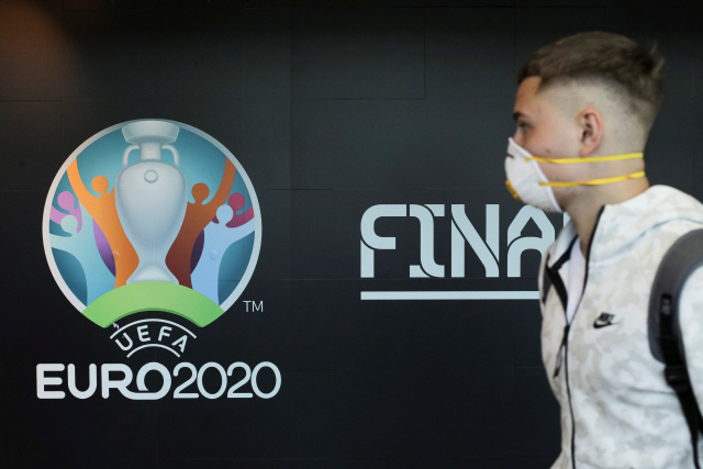17일 루마니아 부쿠레슈티 공항에서 한 여행객이 벽에 붙은 유로2020 로고를 바라보고 있다. /부쿠레슈티=로이터연합뉴스
