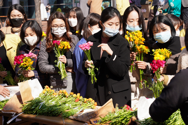 18일 부산 사상구청에서 열린 화훼농가 돕기 직거래장터에서 마스크를 쓴 공무원들이 구매할 꽃들을 고르고 있다.    /사진제공=부산 사상구