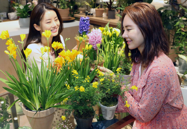 19일 서울 신세계백화점 강남점 라마라마 플라원 매장에서 모델들이 고객에게 꽃화분을 나눠주고 봄을 알리는 ‘오감만족’ 마케팅 행사를 선보이고 있다. 신세계백화점은 코로나19 확산으로 어려움에 빠진 화훼농가를 돕기 위해 이번 행사를 마련했다./권욱기자 2020.3.19