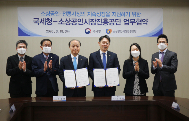 조봉환(왼쪽 세번째) 소진공 이사장이 19일 대전 본부에서 김현준 국세청과 상호 협력 업무협약을 맺고 협약서를 들어보이고 있다. / 사진제공=소진공