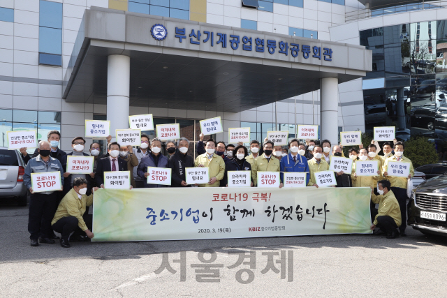 서울경제가 진행하는 <코로나19 극복, 우리가 함께 합니다> 캠페인에 공감한 김기문 중소기업중앙회장과 부산·울산·경남지역 지역 중소기업 대표들이 19일 부산기계공업협동조합 건물 앞에서 다양한 응원 문구가 적힌 팻말을 들어 보이고 있다. 김 회장은 “캠페인 취지에 적극 공감해 첫 주자로 나서게 됐다”고 말했다.360만 중소기업을 대변하는 중기중앙회는 중기의 경영 애로를 정부에 적극 건의해 정책에 반영시키고 있고, 최근에는 영세 소상공인을 위한 ‘착한임대인 운동’도 주도하고 있다. 얼마 전에는 대구·경북 지역에 마스크 3만개를 전달했다. /사진제공=중기중앙회