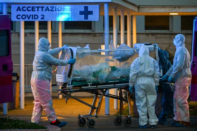 이탈리아 로마의 게멜리 병원이 코로나19 대응을 위해 신설한 콜룸부스 2호 임시병원에서 16일(현지시간) 방호복을 입은 의료진이 들것을 이용해 환자를 옮기고 있다. /로마=AFP연합뉴스