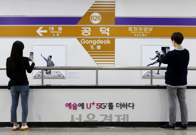 시민들이 서울 지하철 6호선 공덕역이 마련된 ‘U+5G 갤러리’를 체험해보고 있다./사진제공=LG유플러스