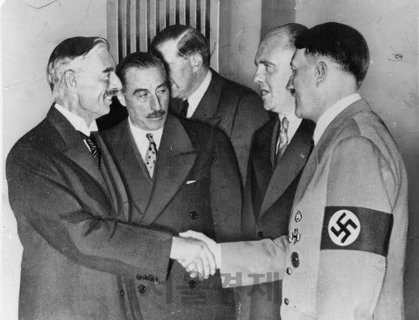 네빌 체임벌린(왼쪽) 영국 수상과 아돌프 히틀러 독일 총통이 1938년 9월 뮌헨에서 만나 악수하고 있다. 체임벌린 수상은 이날 만남에서 상대의 전쟁 야욕을 파악하지 못하는 실수를 범했다./사진=위키피디아