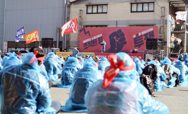 현대중공업 노동조합 조합원들이 20일 코로나19 확산을 우려해 마스크를 쓰고 비옷을 입고 파업 집회를 하고 있다. /시진제공=현대중공업 노조