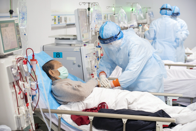 21일 중국 후베이성 우한시의 한 병원에서 의사가 코로나19에 걸린 환자를 치료하고 있다./우한=신화연합뉴스
