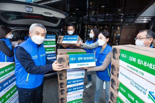 박종복(왼쪽 두번째)SC제일은행장이 서울 종로구 SC제일은행 본점에서 임직원들이 대구동산병원의 의료진들에게 전달할 마스크를 수송 차량에 싣고 있다. /사진제공=SC제일은행