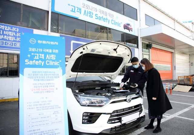 쌍용차 정비담당자가 서비스 네트워크를 방문한 고객과 정비 상담을 진행하고 있다./사진제공=쌍용차