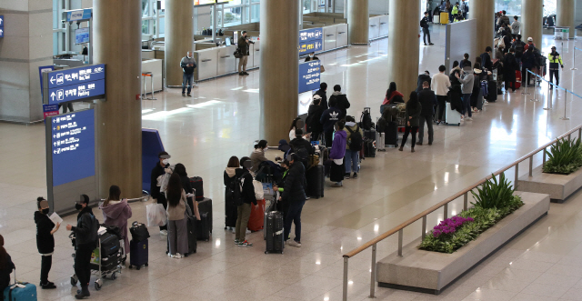 23일 오전 인천국제공항 1터미널에서 영국 런던발 여객기를 타고 입국한 승객들이 진단 검사를 받는 곳으로 향하는 차량으로 이동하고 있다. /연합뉴스