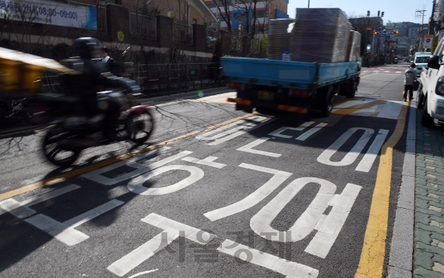 어린이보호구역에서 아동 교통사고 처벌을 강화하는 '민식이법'의 시행을 하루 앞둔 24일 과속단속카메라가 설치되지 않은 서울 중구의 한 초등학교 어린이보호구역에서 걷고 있는 어린이 옆으로 차량들이 빠른 속도로 주행하고 있다. 서울시는 내년까지 관내 초등학교 주변 어린이보호구역 606곳에 과속단속카메라 설치를 완료할 계획이다./오승현기자 2020.03.24