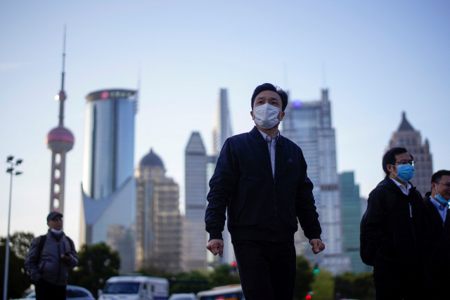지난 19일 마스크를 한 상하이 시민들이 루자주이금융가를 걷고 있다. /로이터연합뉴스