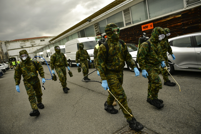 스페인 군인들이 23일(현지시간) 북부 빌바오의 아반도기차역에서 코로나19 확산 방지를 위한 소독작업을 벌이고 있다.   /빌바오=AP연합뉴스
