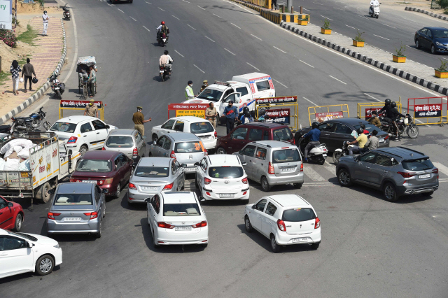인도의 경찰들이 23일(현지시간) 델리-우타르 프라데시 경계 검문소에서 신종 코로나바이러스 감염증(코로나19) 확산 방지를 위해 우타르 프라데시 주 일부 지역이 봉쇄된 것과 관련, 차량을 통제하고 있다. /가지푸르=AFP연합뉴스