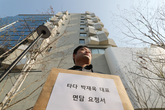 김태환 타다드라이버비상대책위원회 위원장이 25일 오전 서울 성동구 타다 운영사 ‘VCNC 본사’ 앞에서 열린 ‘타다 중단 철회 및 대책 제시 촉구 기자회견’에서 박재욱 VCNC 대표와의 면담 요청서를 들고 있다./연합뉴스