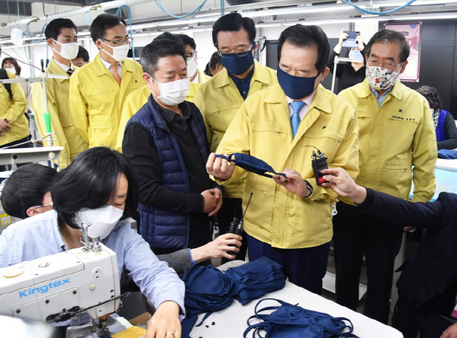 정세균(오른쪽 두번째) 국무총리와 박원순(〃첫번째) 서울시장이 25일 서울 용산구 서계동에 위치한 한 봉제업체를 찾아 필터 교체형 마스크 제품을 살펴보고 있다./사진제공=서울시