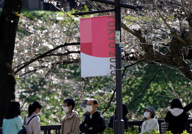 25일 일본 도쿄에서 마스크를 쓴 시민들이 거리를 지나고 있다./도쿄=로이터연합뉴스