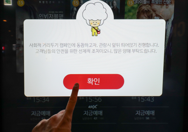 지난 22일 서울 시내 한 영화관 예매 화면에 사회적 거리두기 캠페인 안내문이 표시되고 있다./연합뉴스