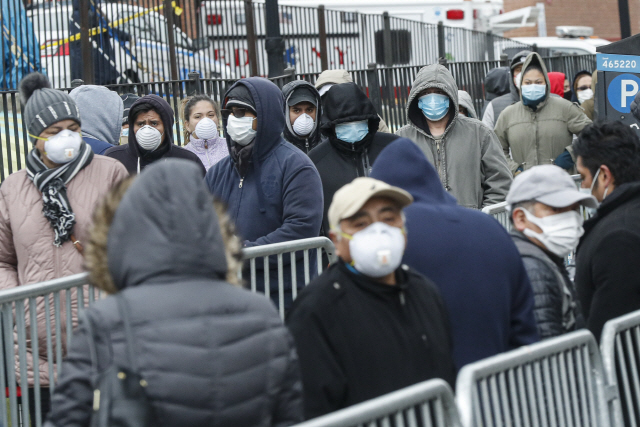 25일(현지시간) 미국 뉴욕 퀸스의 엘름허스트 병원 입구에서 시민들이 마스크를 쓴 채 신종 코로나바이러스 감염증(코로나19) 검사를 받기 위해 줄을 서서 차례를 기다리고 있다./뉴욕=AP연합뉴스