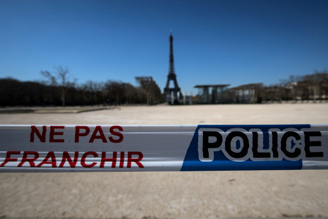 25일(현지시간) 에펠탑 앞에 위치한 프랑스 파리의 샹드마르스 공원 입구에 ‘들어가지 마시오(NE PAS FRANCHIR)’라고 적힌 차단선이 설치돼 있다. 지난 17일 프랑스 정부는 전국에 이동금지령을 내렸다./파리=AFP연합뉴스