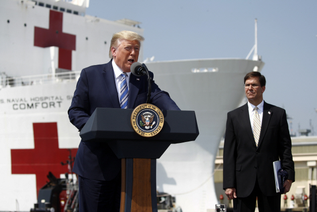 도널드 트럼프(왼쪽) 미국 대통령이 28일(현지시간) 버지니아주 노퍽해군기지에 정박한 해군 병원선 ‘USNS 컴퍼트’ 앞에서 연설하고 있다. 이 병원선은 이날 뉴욕의 코로나19 환자 수용을 위해 뉴욕으로 향했다. /노퍽=AP연합뉴스